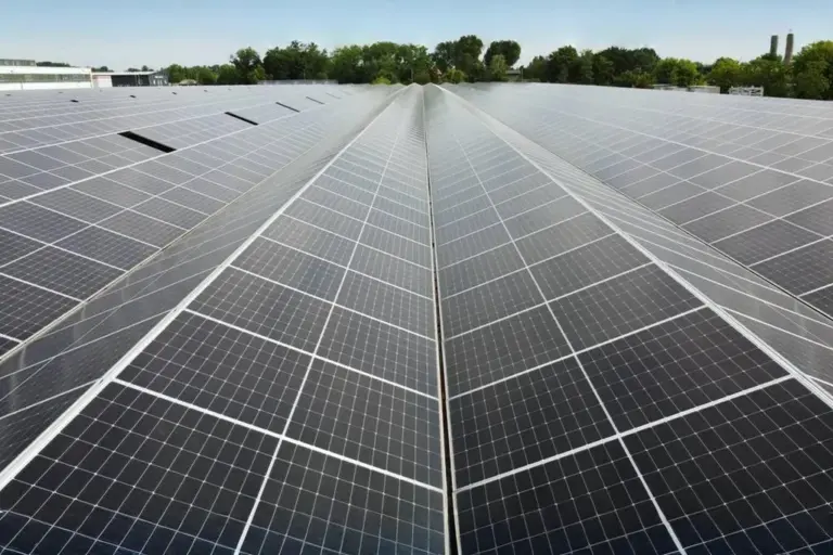 Freiflächen-PV-Anlage mit symmetrischer Modulstruktur und grüner Umgebung im Hintergrund