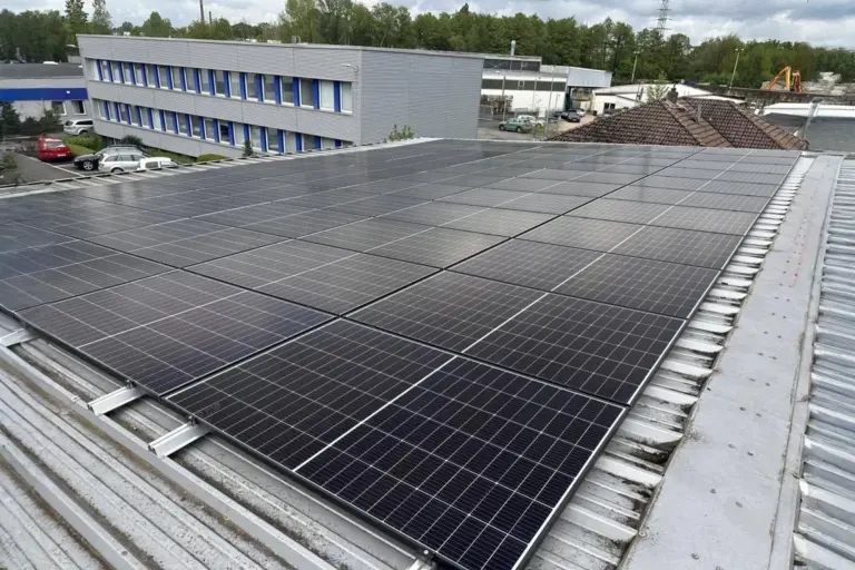 Gewerbegebäude mit Flachdach-Photovoltaikanlage, modernes Verwaltungsgebäude im Hintergrund