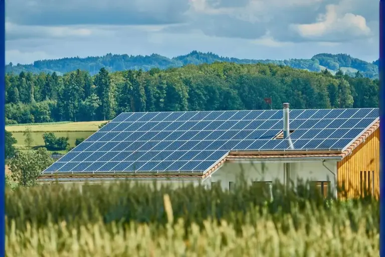 Photovoltaikanlage auf Einfamilienhaus am Land mit Feldern und Wäldern im Hintergrund