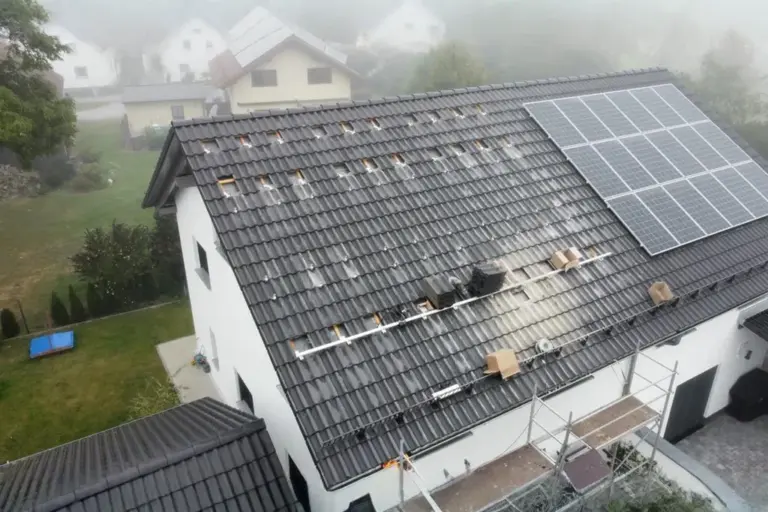 Montage einer PV-Anlage auf Einfamilienhausdach, sichtbare Unterkonstruktion und Modulinstallation