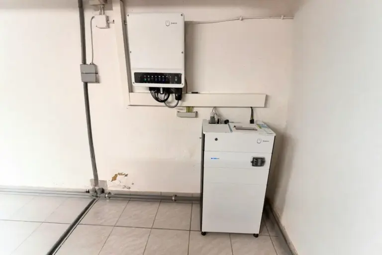 FENECON Heimspeicher mit Wand-Wechselrichter im Keller eines Einfamilienhauses – installiert an einer weißen Wand über Fliesenboden
